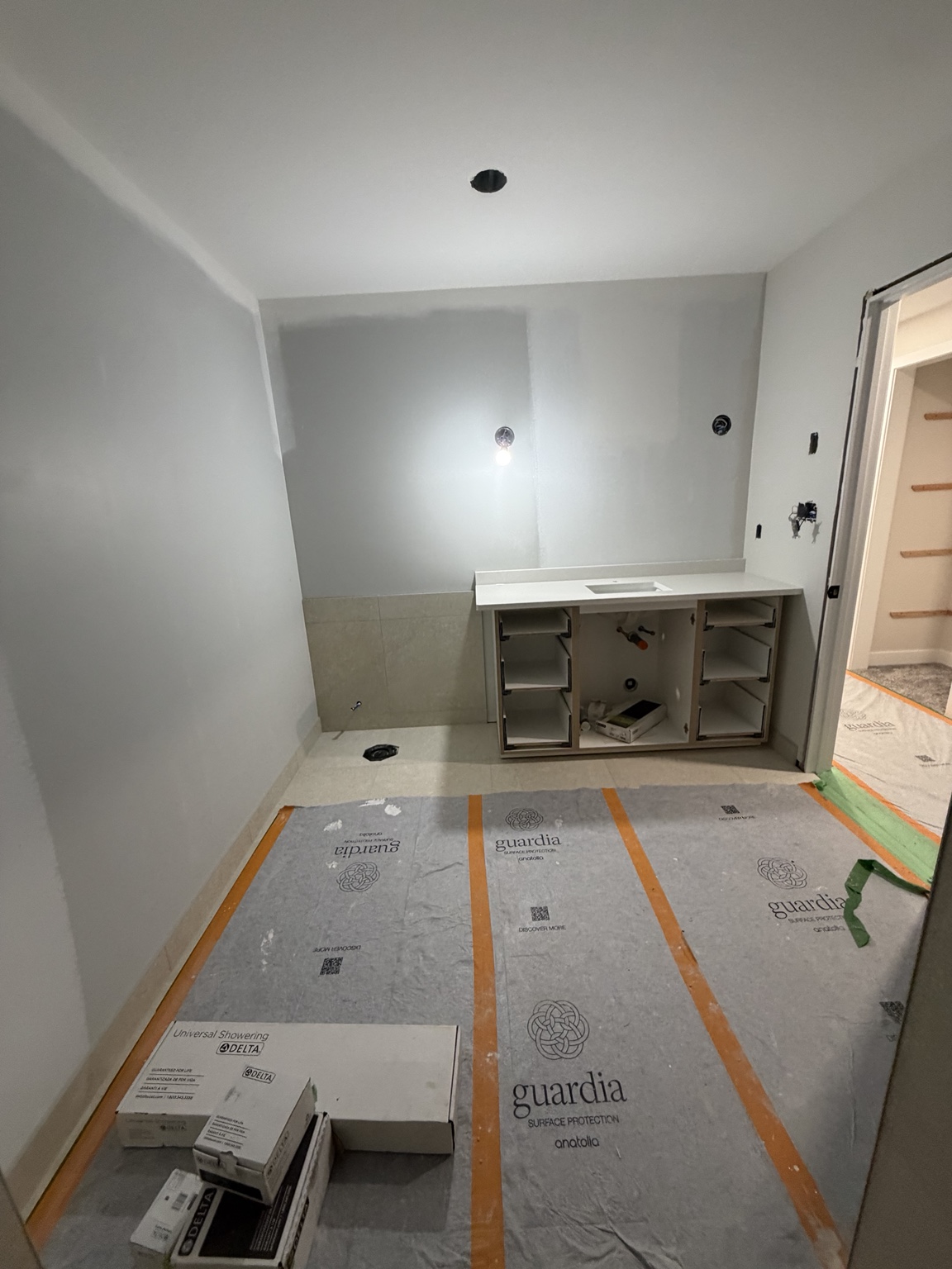 Bathroom renovation with installed vanity and protected tile floor